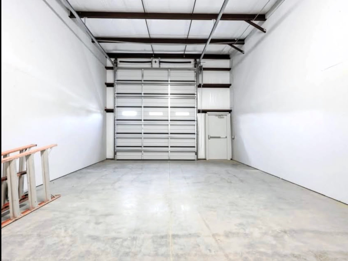 Interior of a Flexbays warehouse bay in Sydney NS with the 12 by 14 ft drive-in overhead door and separate man door