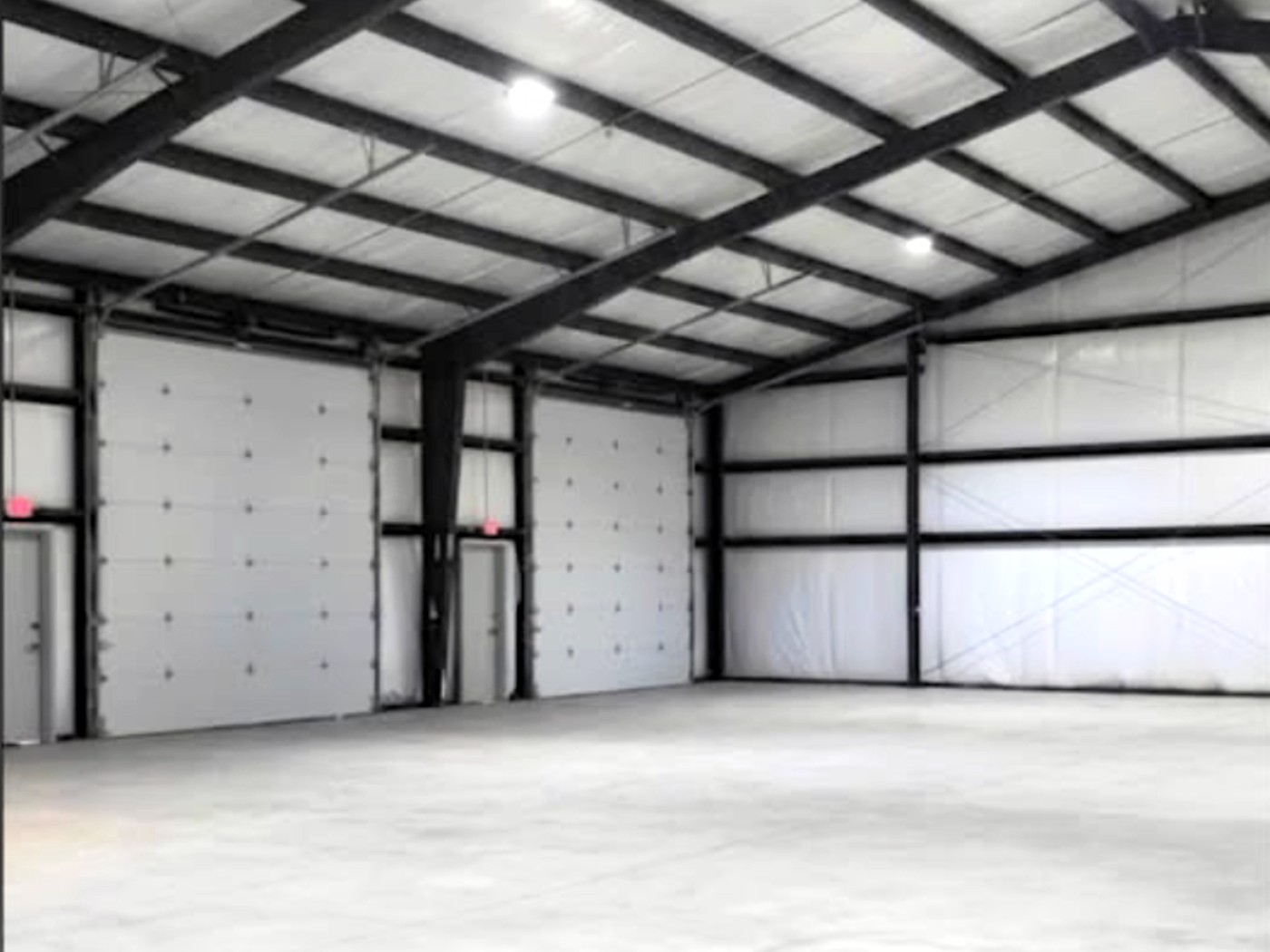 Clear-span warehouse interior showing multiple overhead doors and no interior columns